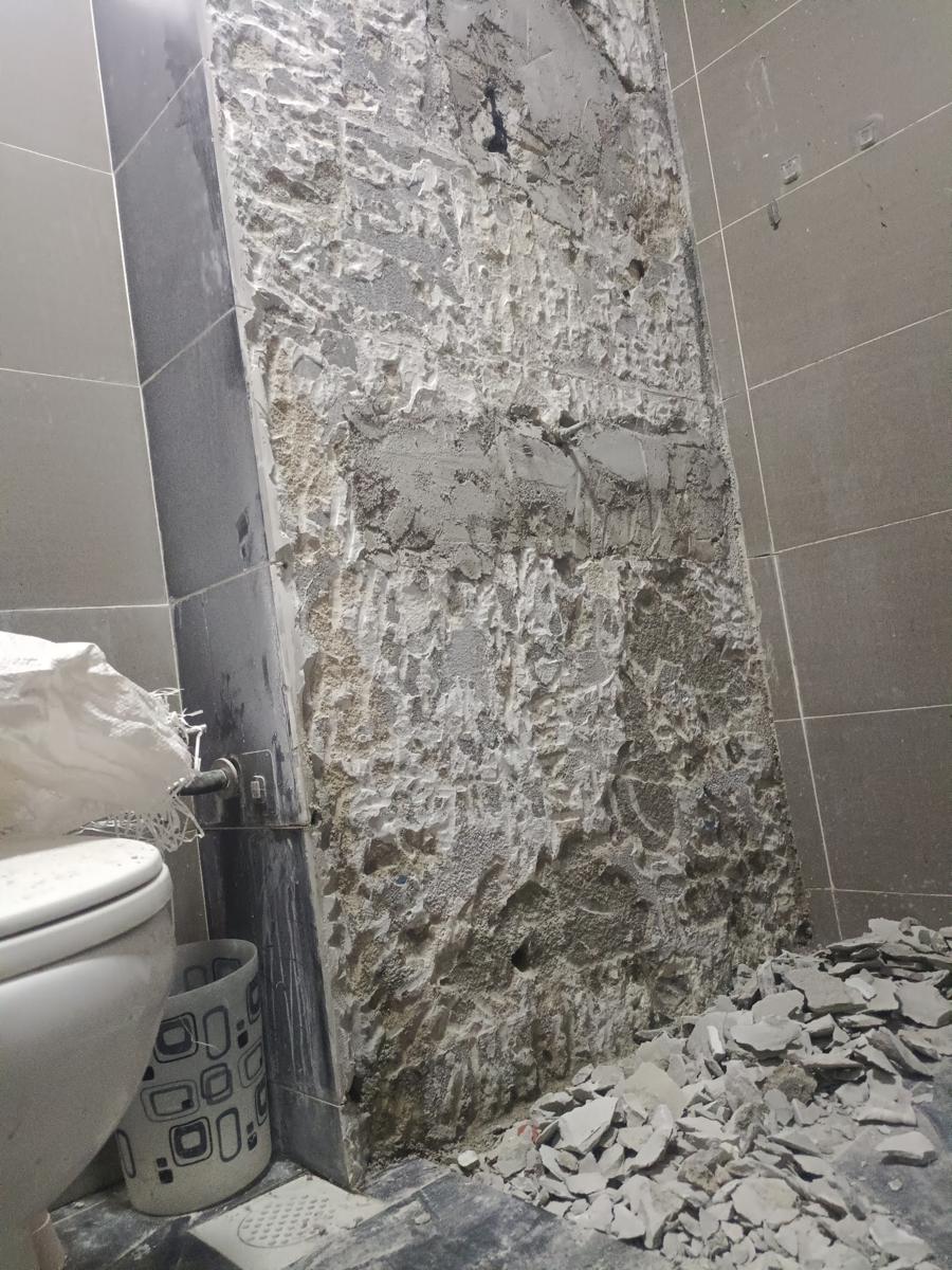 Bathroom wall after tile hacking